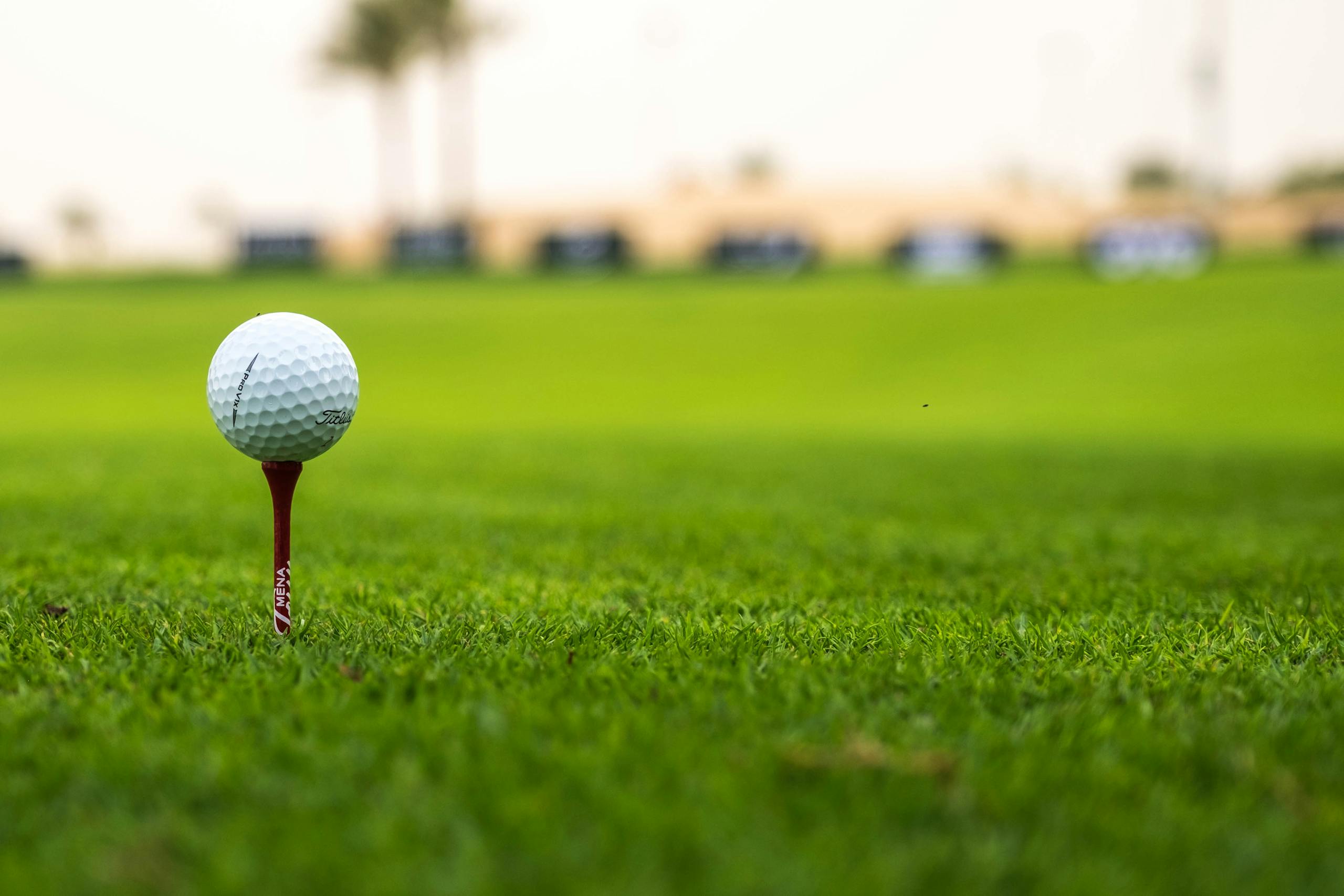 Close-up of a golf ball on a tee on a vibrant fairway.