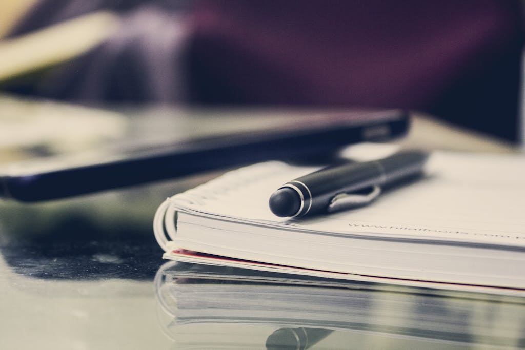 Close-up of an elegant pen resting on an open notebook in a stylish office environment.