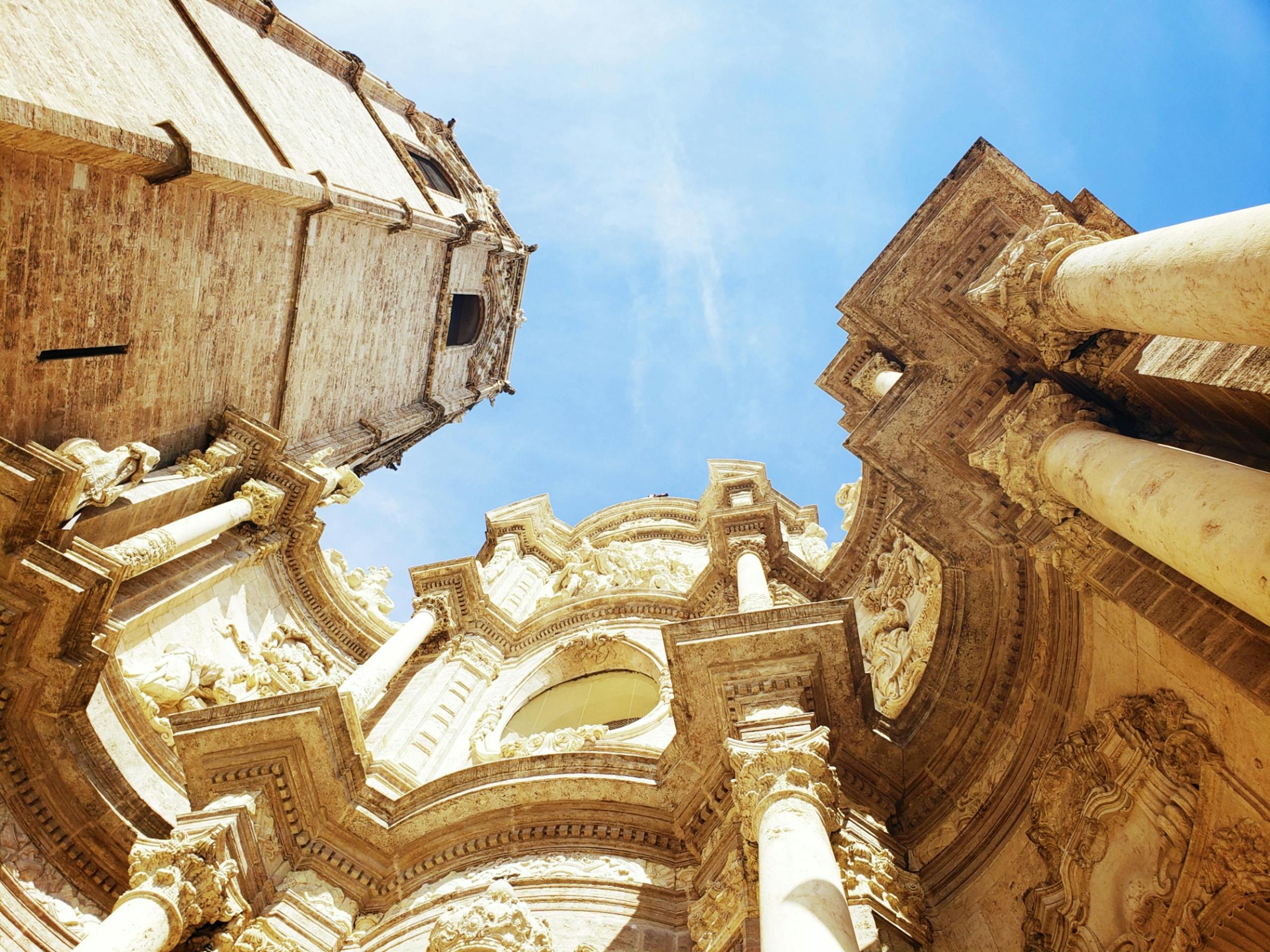 A stunning low-angle view of Baroque architectural details with blue sky above.