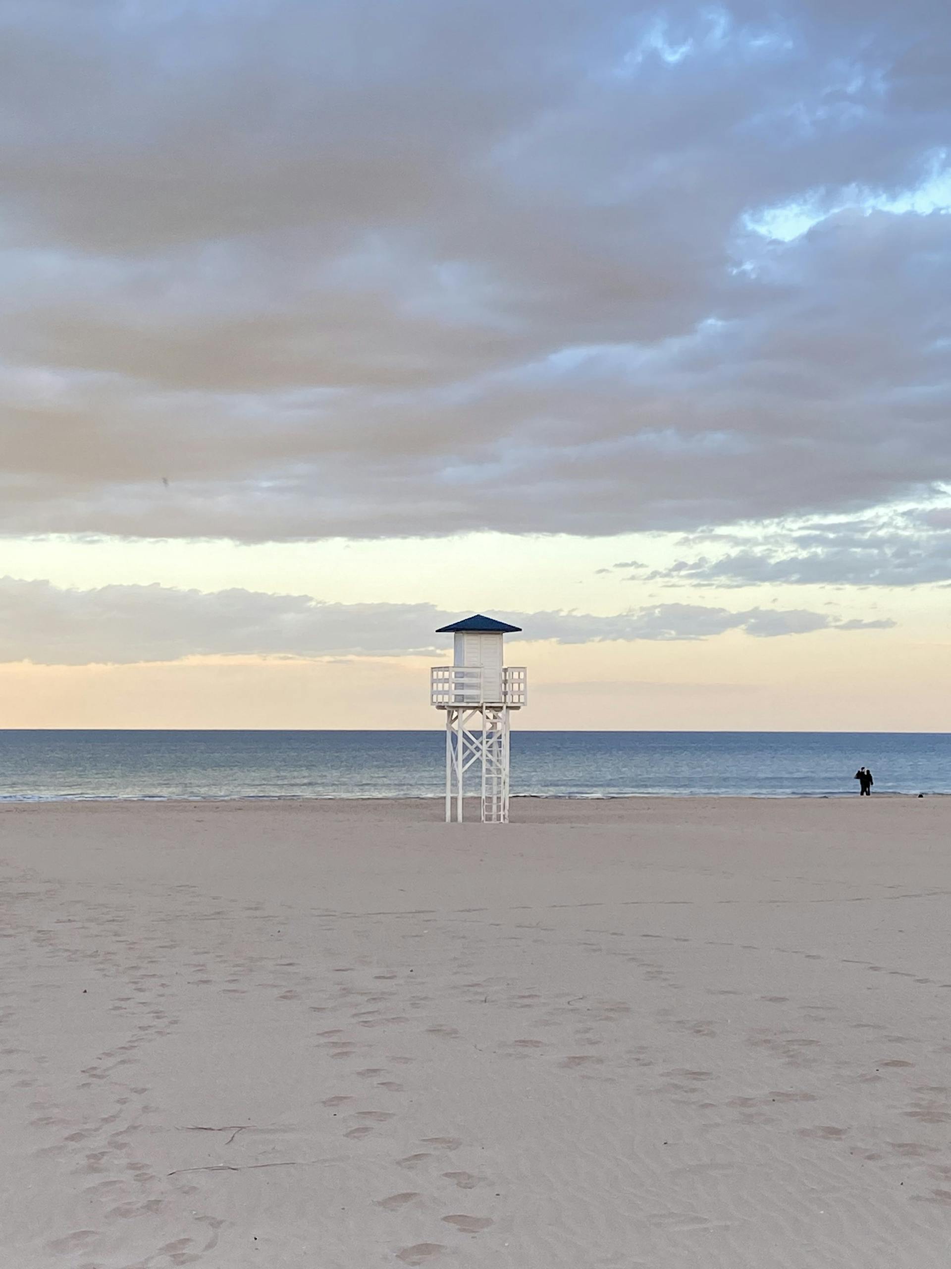 Calm evening at Playa de Gandía with a lifeguard tower and scenic sky.