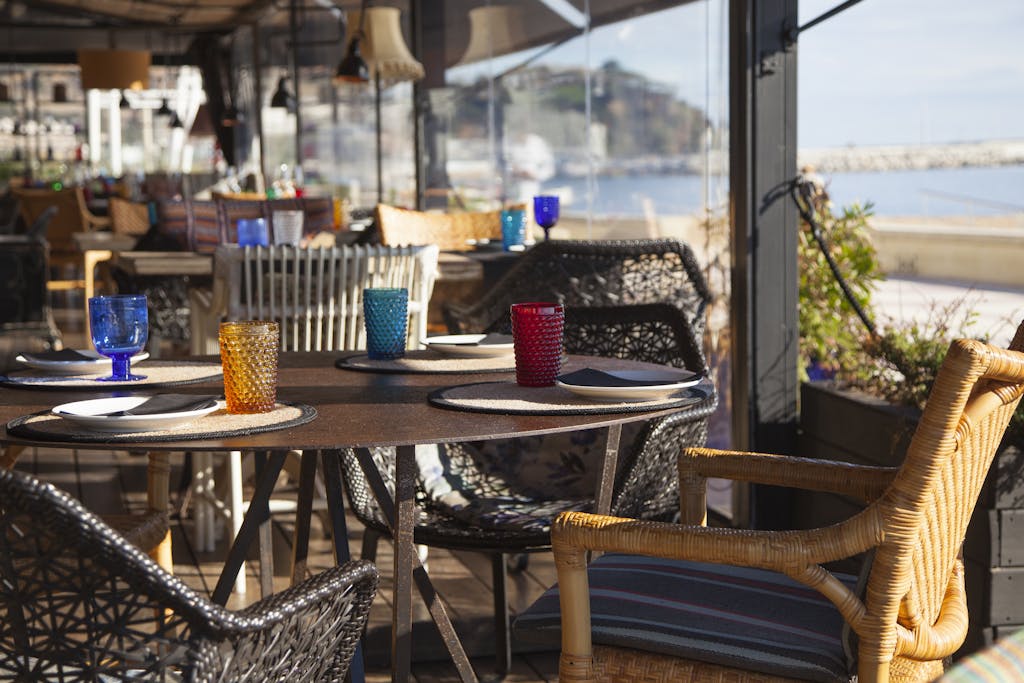Elegant seaside restaurant with a stunning terrace view and vibrant glassware.