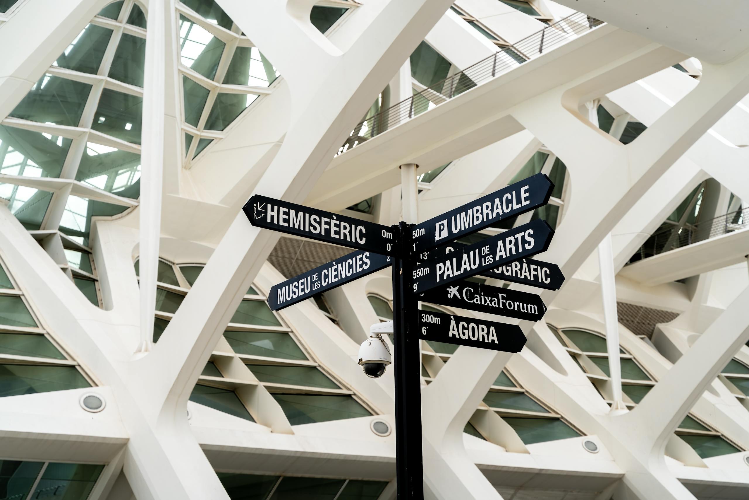 Modern architectural design with directional signs at Valencia's City of Arts and Sciences.
